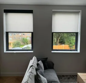 Two Electric Roller Blinds - on two windows side by side - one has Decorquip Capital Fascia 120mm fitted - one does not