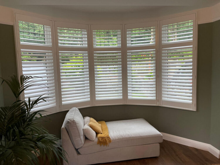 white painted wooden plantation shutters in this East London Bay window